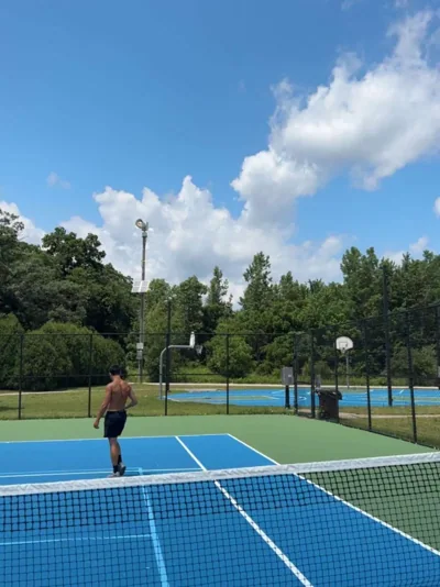 A bright blue outdoor court and an afternoon outside.