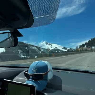 A snowy mountain view from the passenger side of a car.