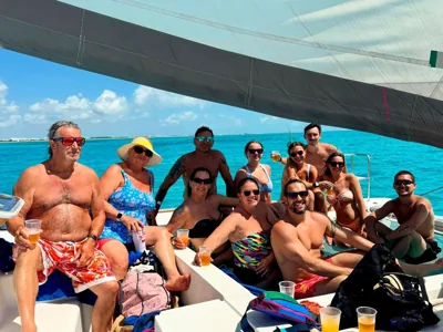 A group together on a boat in bright blue water.