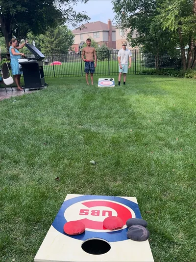 People playing a lawn game in a green backyard.