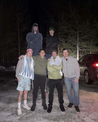 A group posing together outside at night.
