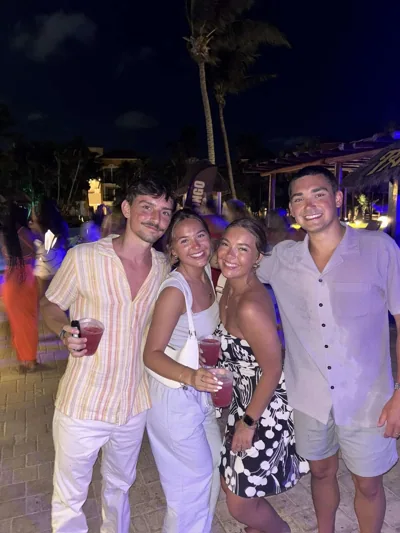A group smiling together after dark.