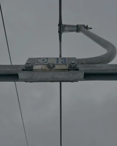 Looking up at the chairlift cable and metal grip.