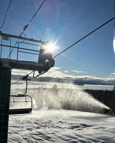 Sunlight shining through a ski lift over snow.