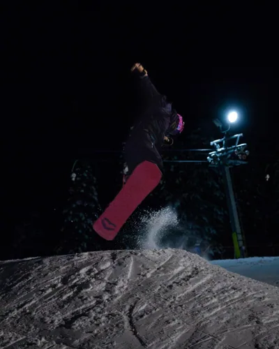 A snowboard jump photographed at night.