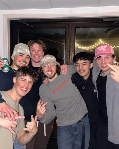 Friends together in a doorway at night.