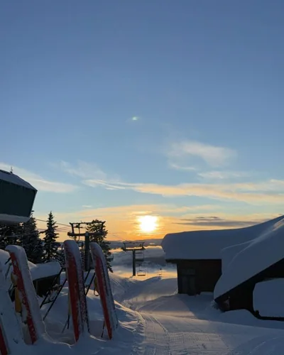 Low sun over a snowy ski-lift station.