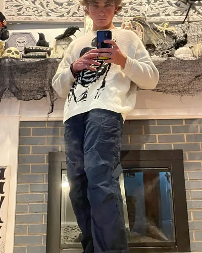 A mirror portrait in a light graphic sweater.