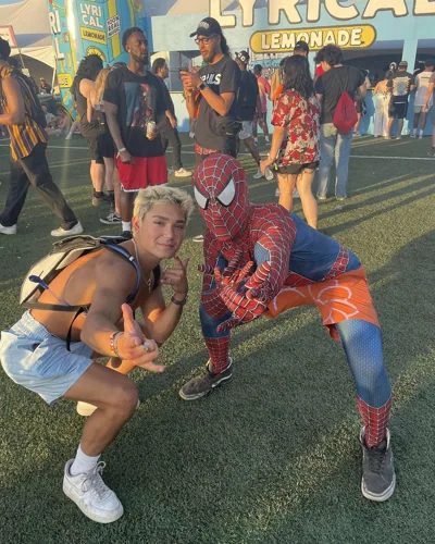 A festival photograph beside a person in a Spider-Man costume.
