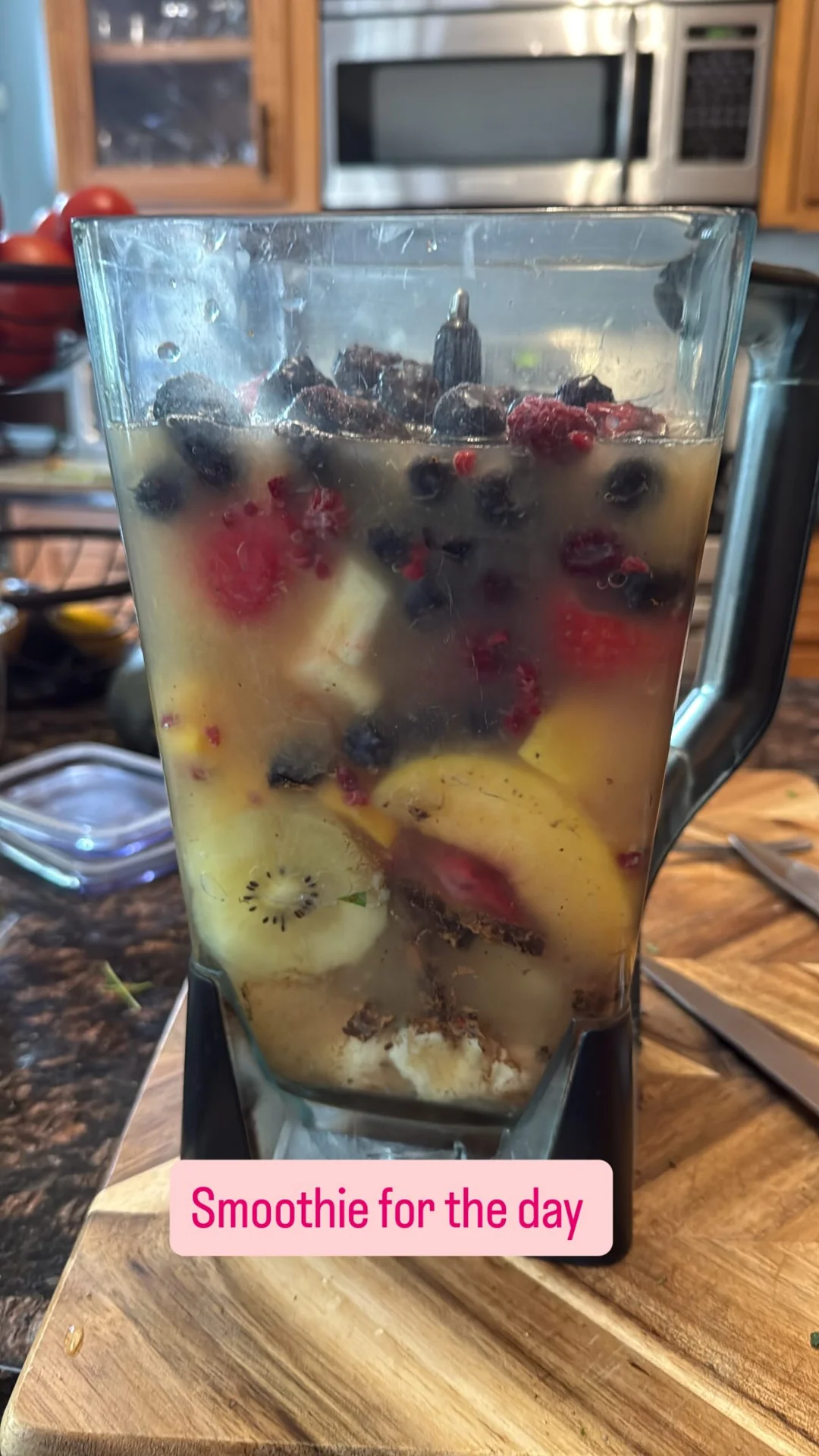 A blender filled with berries, kiwi and other fruit.