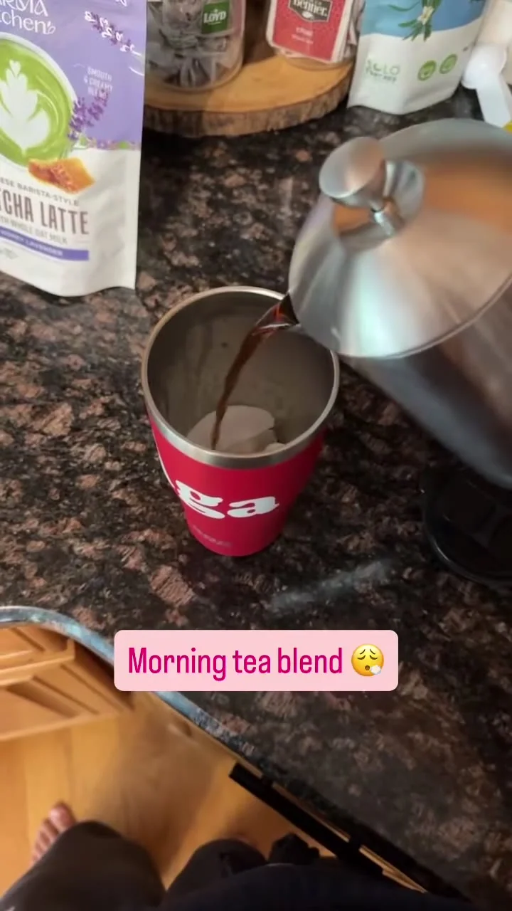 Metal press pouring into a red cup on a kitchen counter.