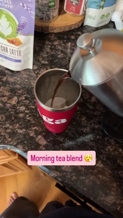 Metal press pouring into a red cup on a kitchen counter.