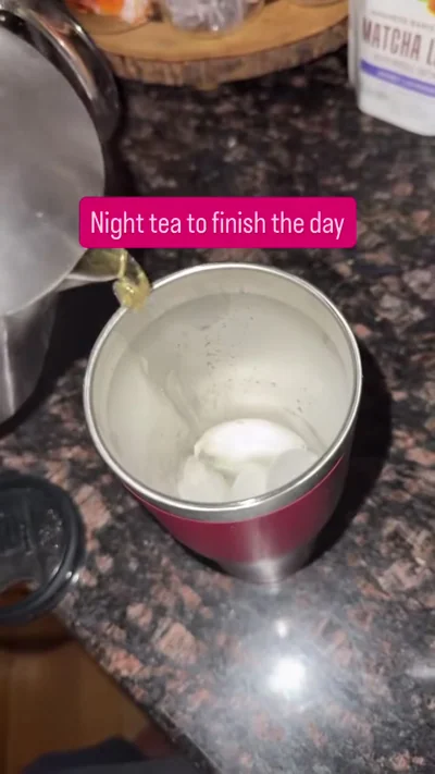 Lighter tea pouring into a red cup.