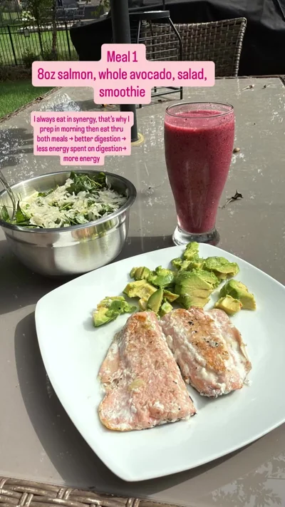 Patio meal with salmon, avocado, salad and pink smoothie.